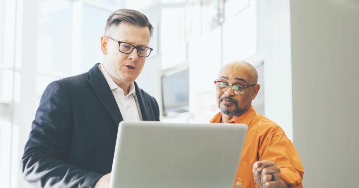 Two men working together on a computer
