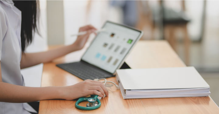 Woman working at desk with stethoscope